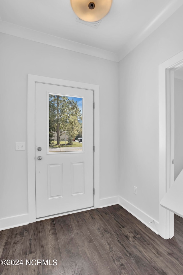 foyer with ornamental molding and dark hardwood / wood-style flooring