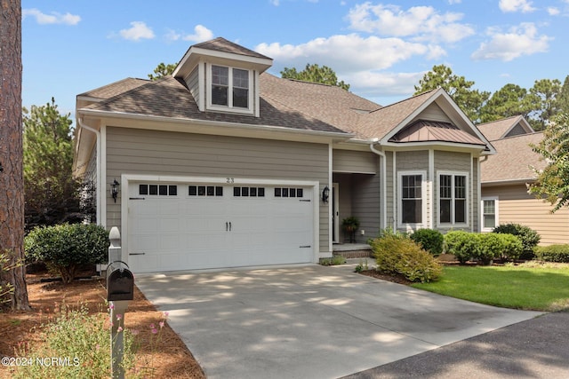 view of front of house featuring a garage, driveway, and a shingled roof