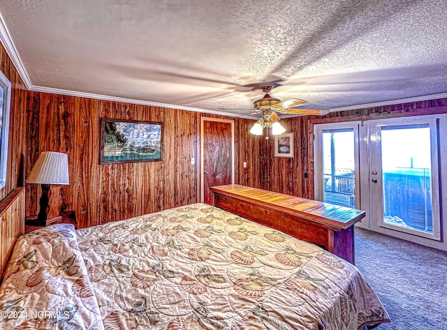 unfurnished bedroom featuring access to exterior, crown molding, carpet flooring, wood walls, and a textured ceiling