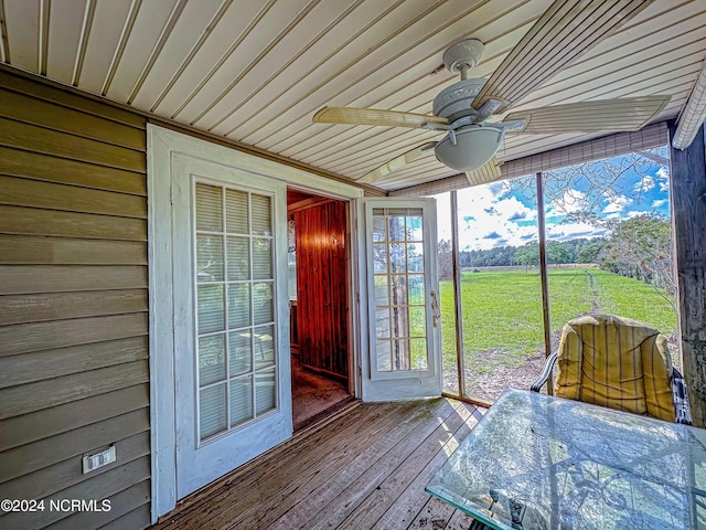 unfurnished sunroom featuring wooden ceiling and a ceiling fan