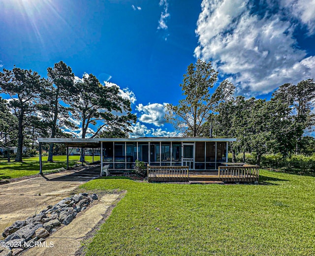 view of front facade with a front yard and a sunroom