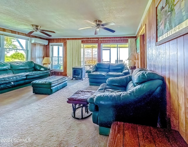 sunroom featuring a wood stove, ceiling fan, and a wall mounted air conditioner