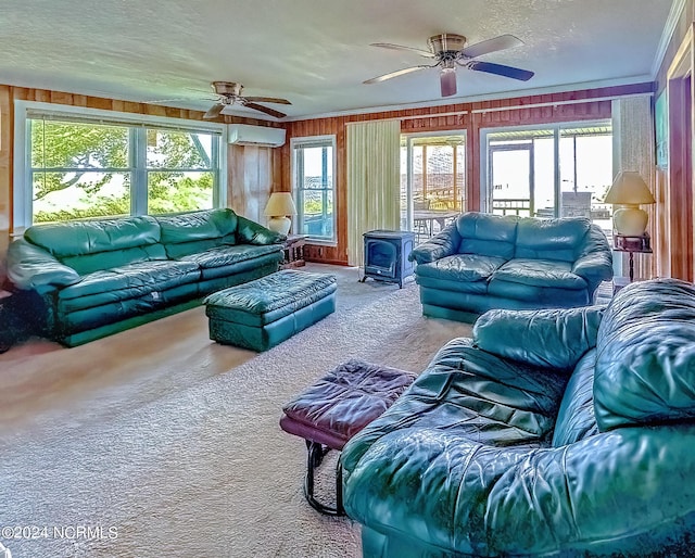 living room with a wood stove, carpet, a textured ceiling, wood walls, and a wall mounted AC