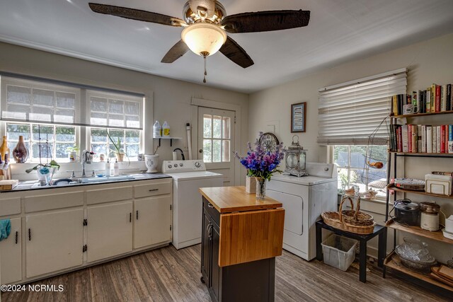 kitchen featuring light hardwood / wood-style flooring, a wealth of natural light, washer and dryer, ceiling fan, and white cabinets