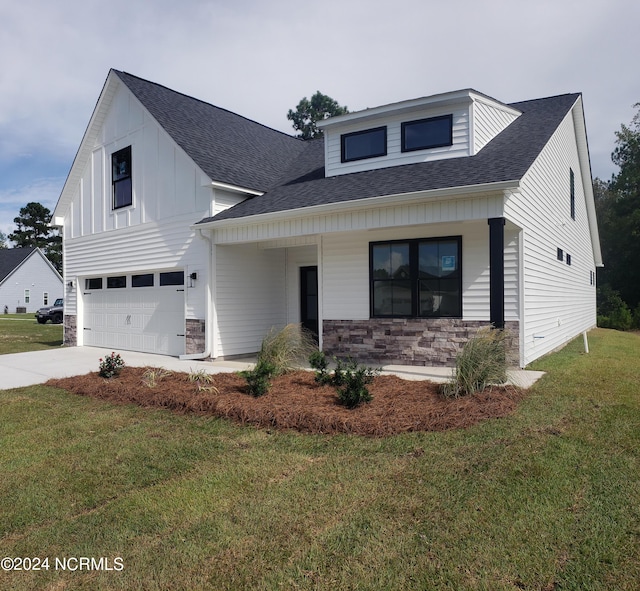 modern farmhouse featuring a garage, a front yard, stone siding, and a shingled roof