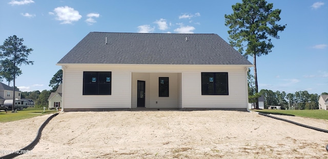 back of house with roof with shingles