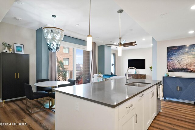 kitchen featuring dark wood finished floors, dark countertops, white cabinets, and a sink