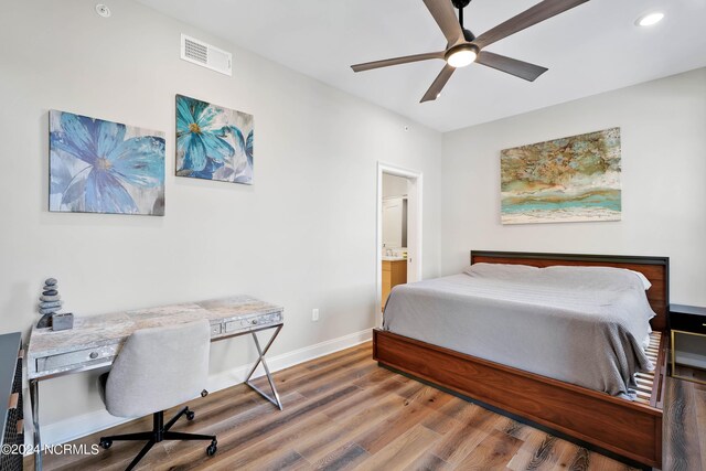 bedroom featuring visible vents, ensuite bath, wood finished floors, recessed lighting, and baseboards