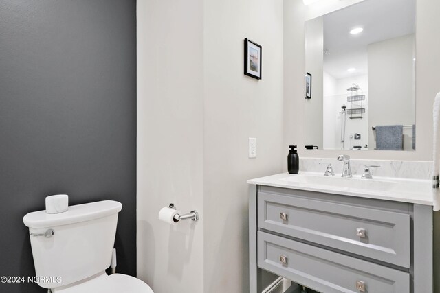 bathroom featuring recessed lighting, toilet, and vanity