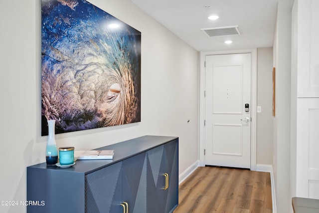 hall featuring visible vents, recessed lighting, baseboards, and wood finished floors