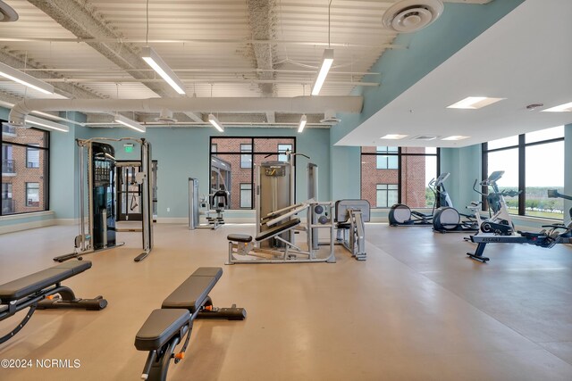 exercise room featuring a high ceiling and baseboards