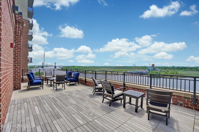 wooden deck featuring an outdoor hangout area and a water view