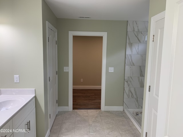 bathroom featuring vanity, tile patterned floors, and tiled shower