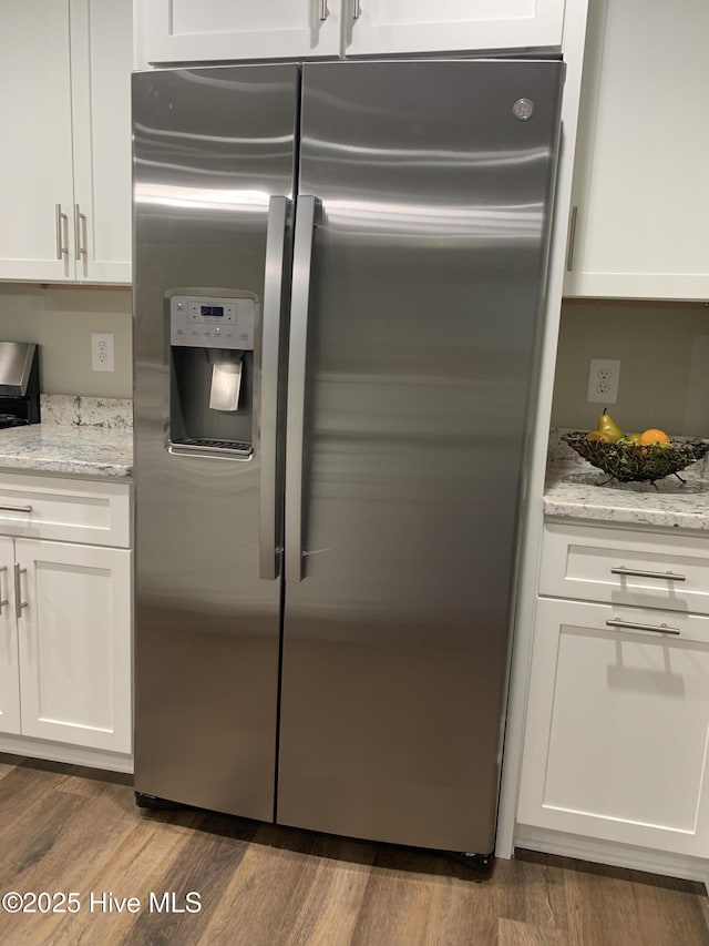 kitchen featuring white cabinetry, hardwood / wood-style flooring, light stone countertops, and stainless steel refrigerator with ice dispenser