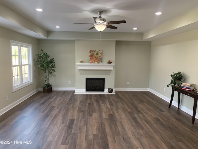 unfurnished living room with dark hardwood / wood-style floors and ceiling fan