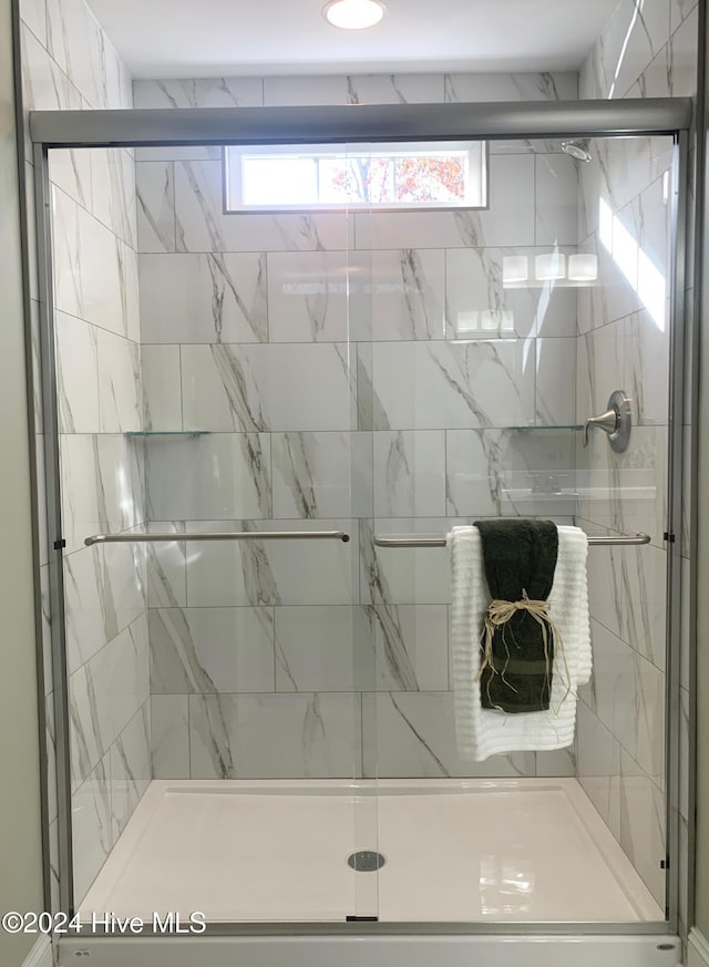 bathroom featuring a healthy amount of sunlight and a shower with shower door