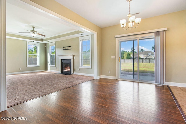 unfurnished living room with wood-type flooring, ceiling fan with notable chandelier, and plenty of natural light