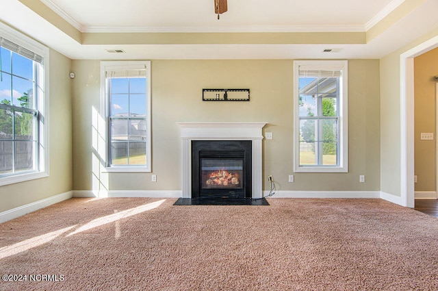 unfurnished living room with a wealth of natural light, crown molding, and carpet floors