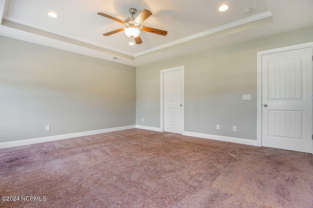 carpeted empty room with ornamental molding, ceiling fan, and a raised ceiling