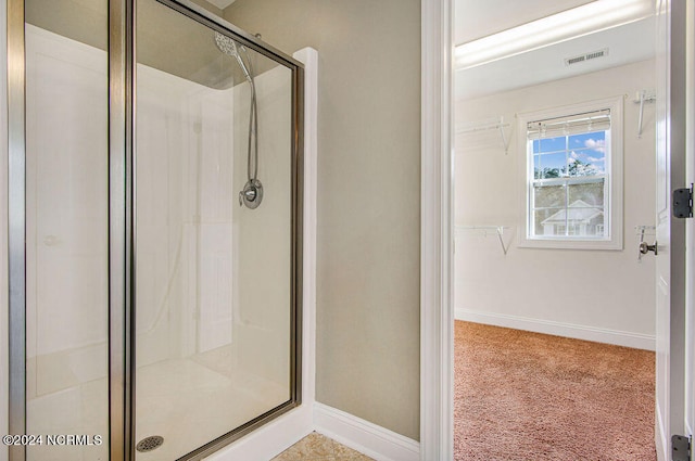 bathroom with a shower with door