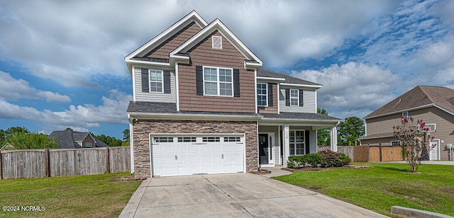 craftsman house featuring a front yard and a garage