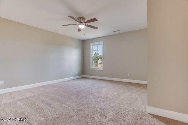 spare room featuring light carpet and ceiling fan