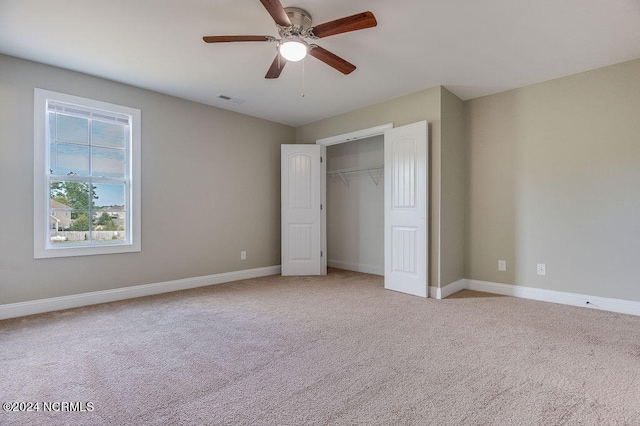 unfurnished bedroom featuring a closet, ceiling fan, and light colored carpet