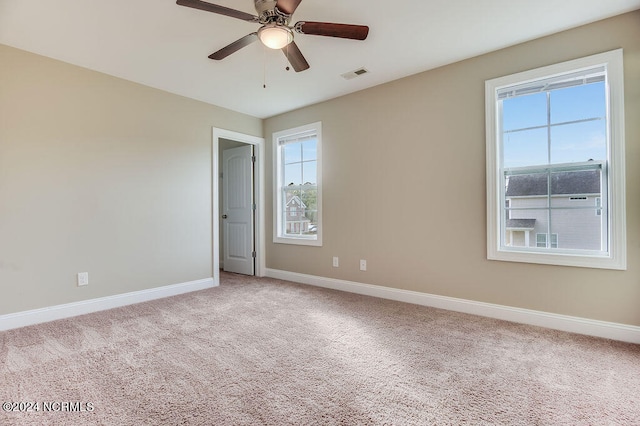 spare room featuring light colored carpet and a healthy amount of sunlight