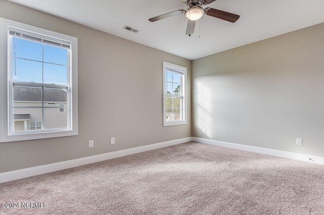 carpeted spare room with ceiling fan