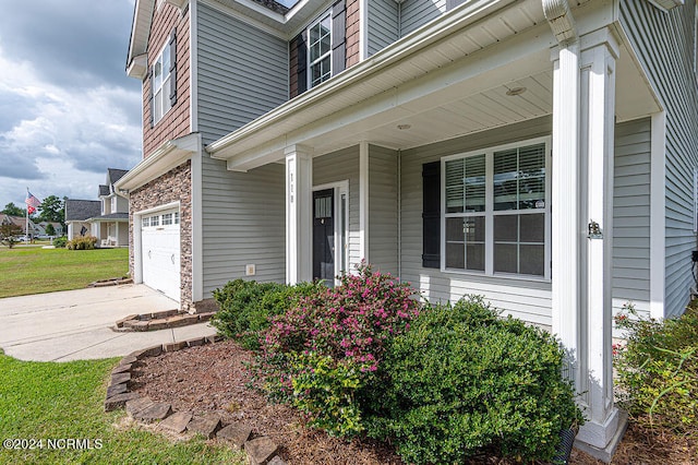 entrance to property with covered porch and a garage