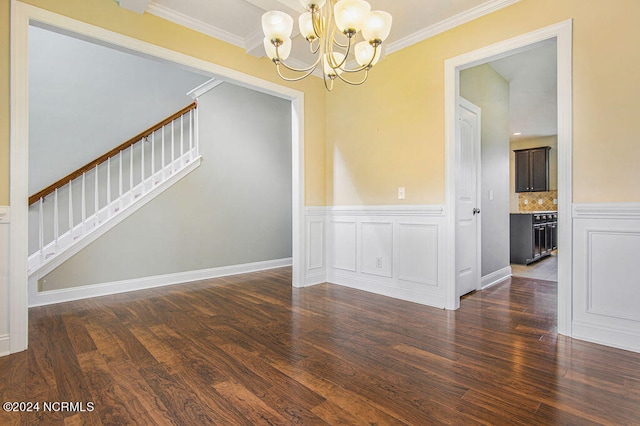 empty room featuring crown molding, dark hardwood / wood-style floors, and a chandelier