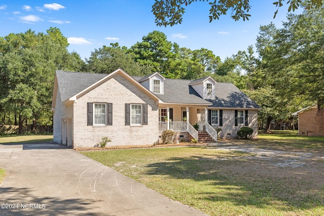 cape cod house featuring covered porch and a front yard