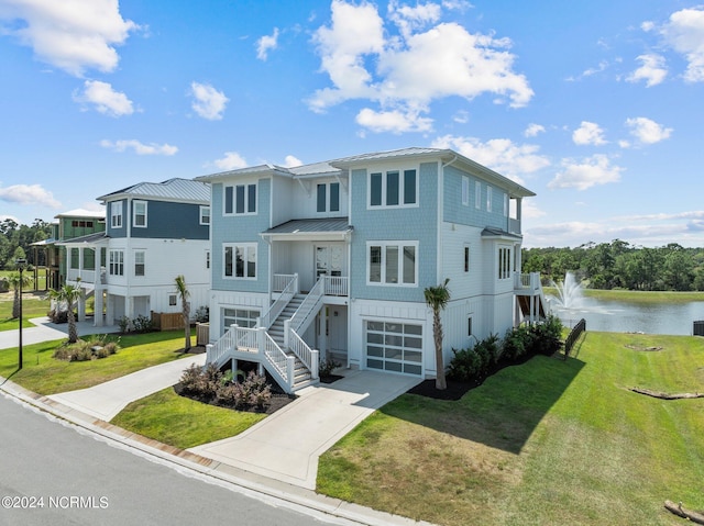 view of front facade with a garage, a water view, and a front lawn