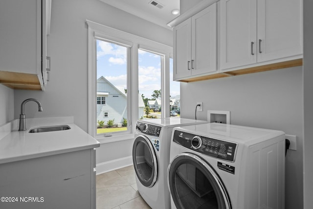 clothes washing area featuring independent washer and dryer, plenty of natural light, cabinets, and sink