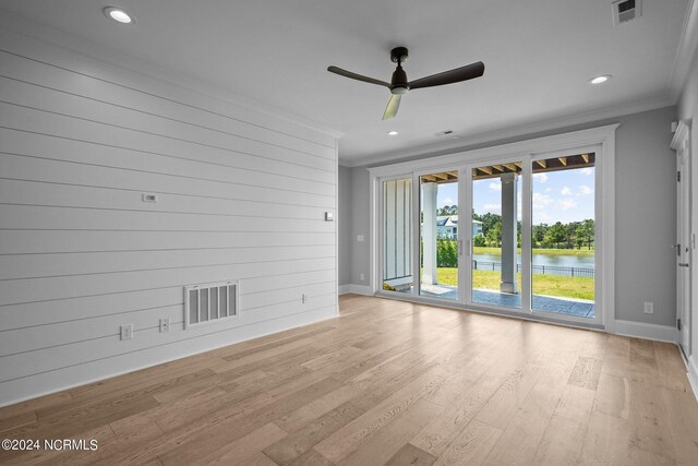 spare room featuring a water view, ceiling fan, ornamental molding, and light hardwood / wood-style flooring