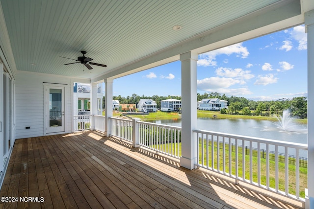 deck featuring a water view, a lawn, and ceiling fan