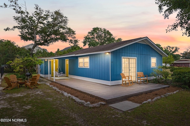 back house at dusk with a deck