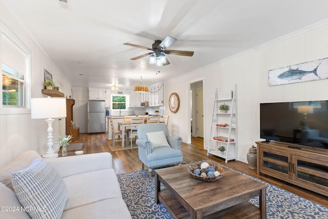 living room with ornamental molding, ceiling fan, and hardwood / wood-style flooring