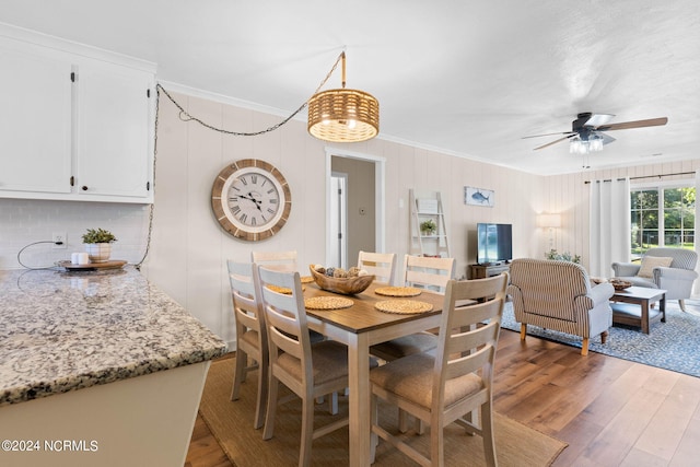 dining area with crown molding, dark wood-type flooring, and ceiling fan