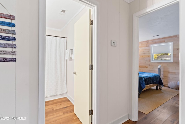 corridor with hardwood / wood-style flooring and wood walls