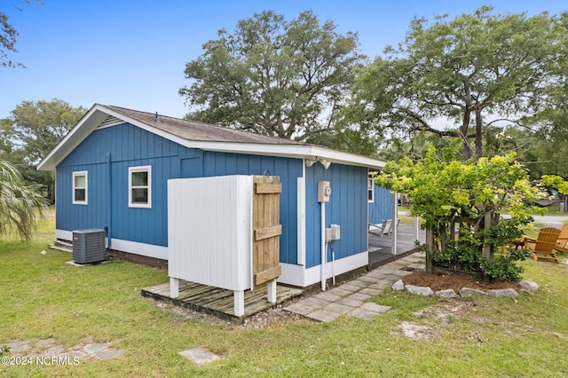 view of outbuilding featuring a lawn and central AC