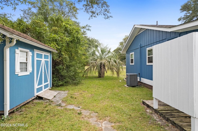 view of yard with a storage shed and central air condition unit