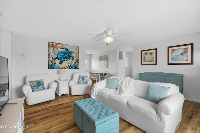 living room featuring ceiling fan, a textured ceiling, and hardwood / wood-style flooring