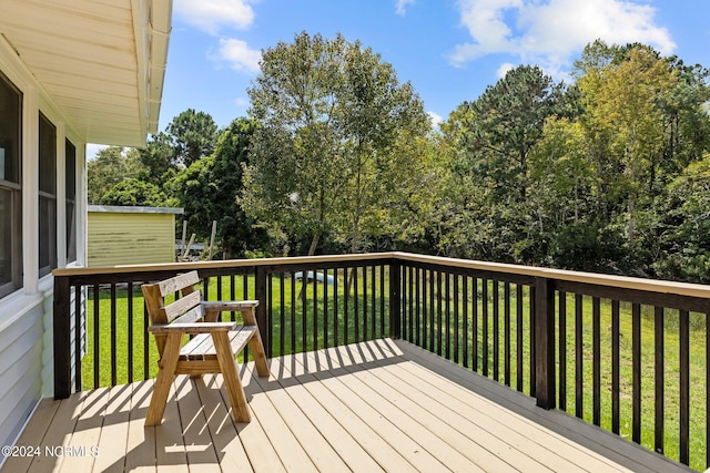 wooden terrace featuring a yard