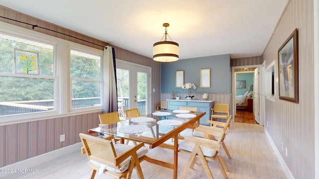 dining area with wooden walls and light hardwood / wood-style flooring