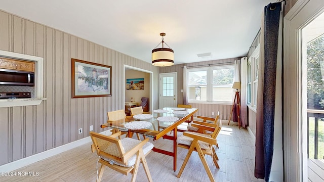 dining room with light wood-type flooring and a healthy amount of sunlight