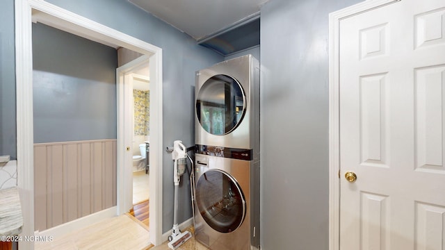 laundry area featuring light hardwood / wood-style floors and stacked washer and dryer