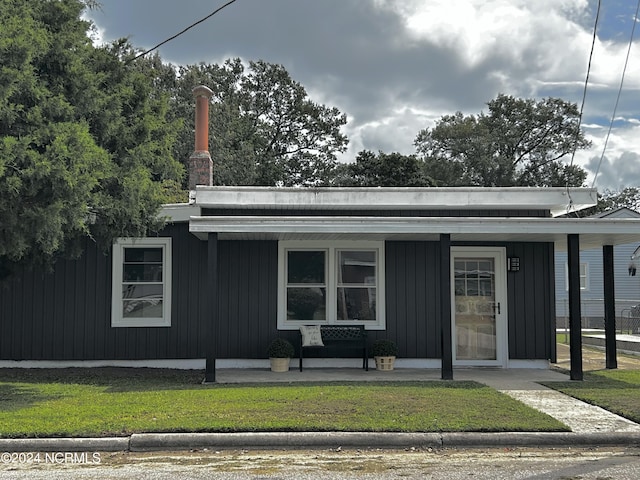 view of front of property featuring board and batten siding, a porch, and a front lawn