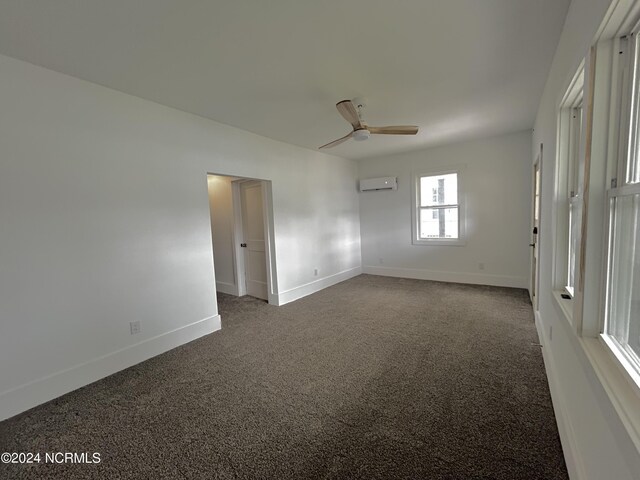 carpeted empty room with ceiling fan and a wall unit AC