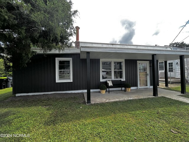 rear view of property with a yard